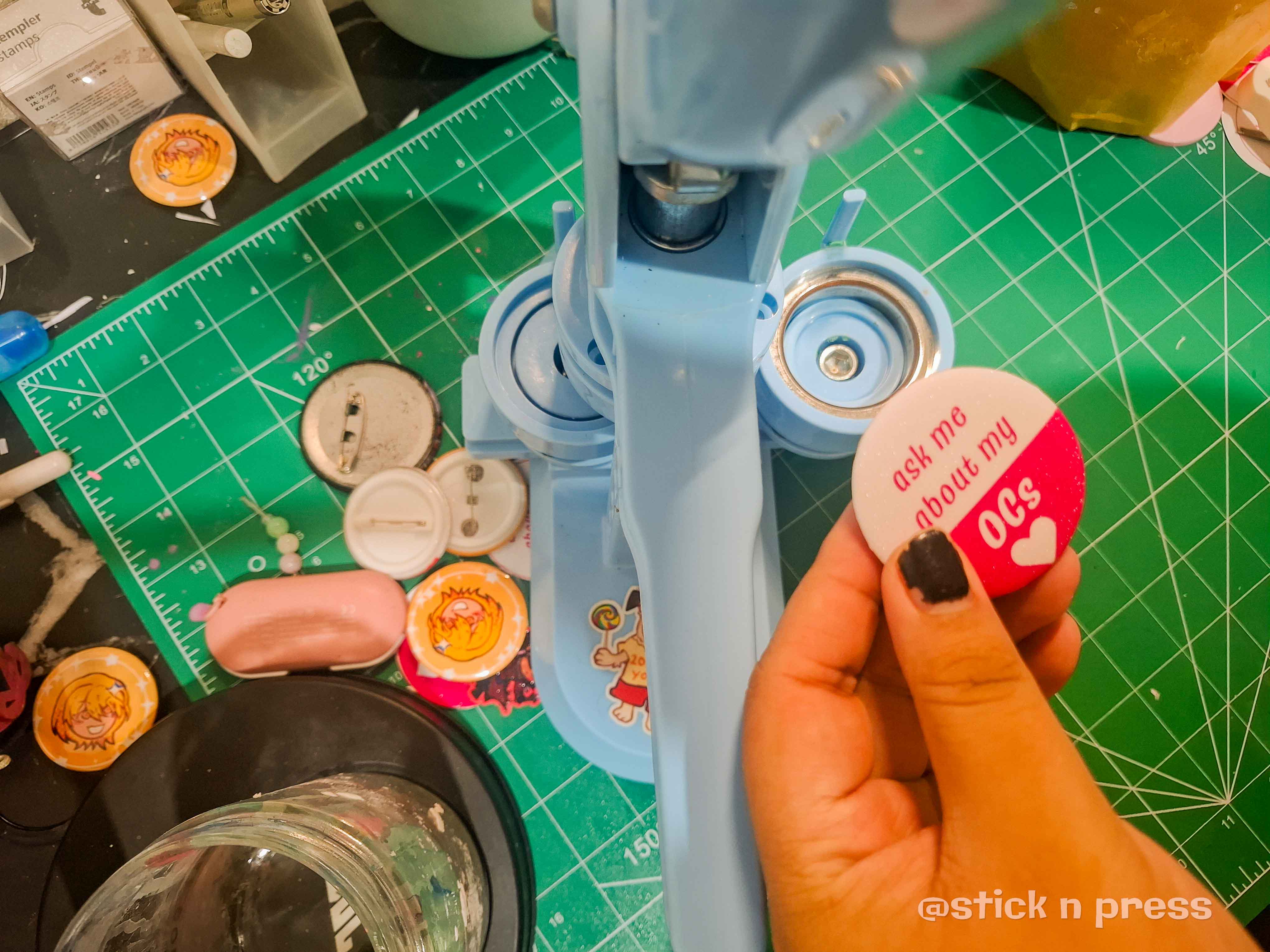 Finished button pin held beside the button pin machine